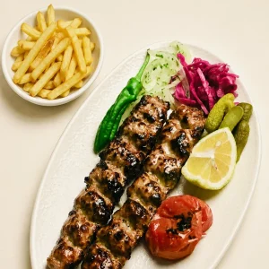 Charcoal-grilled Persian Kubideh kebab served with potatoes at Toranj Persian Restaurant Marbella